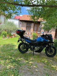 een blauwe motorfiets geparkeerd voor een huis bij Old Court in Curtea de Argeş