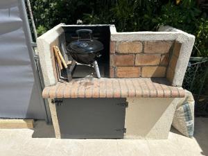 a charcoal grill sitting in a stone box at La pitchounette in Fleury
