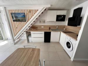 a kitchen with a sink and a washing machine at La pitchounette in Fleury +5 photos