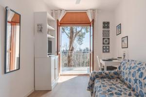 a living room with a couch and an open door at ElTufeto Apartment - Parking and Terrace in Grado-Pineta