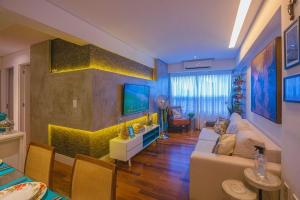 salon z kanapą i telewizorem w obiekcie Conforto e Design a Poucos Passos da Praia w mieście Tambaú