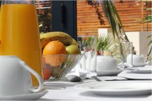 a table with a bowl of fruit on a table at The One 8 Hotel - Solar Power located in Green Point in Cape Town