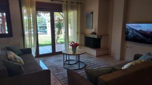 a living room with a couch and a table at Villa Anna III in Nea Moudania