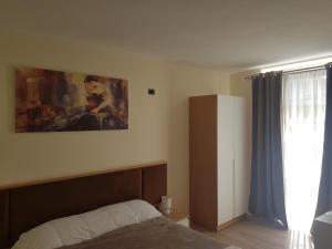 科爾察的住宿－Vila Pllaha，卧室配有一张床,墙上挂有绘画作品