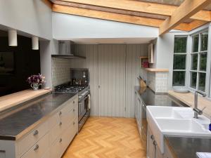 a large kitchen with a sink and a stove at Willow Cottage in Studland