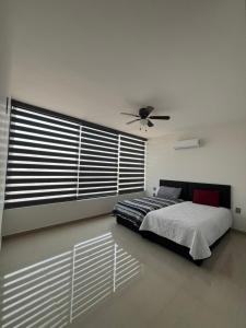 a bedroom with a bed and a ceiling fan at Casa Samu in Tequila