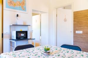 a room with a table with chairs and a television at Appartamento Il Mare Dalla Terrazza in Rio nellʼElba