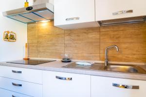 a kitchen with white cabinets and a sink at Appartamento Il Mare Dalla Terrazza in Rio nellʼElba