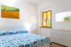 a bedroom with a bed and a dresser and a window at Appartamento Il Mare Dalla Terrazza in Rio nellʼElba