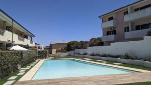 a swimming pool in front of a building at Appartamento con Piscina - Luna Ruja Palau in Palau