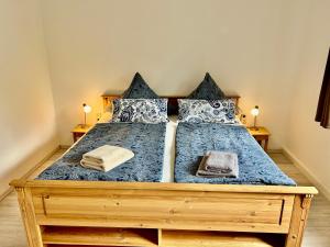 ein Schlafzimmer mit einem Holzbett mit zwei Kissen in der Unterkunft Große Ferienwohnungen 5 - 8 "Pumphut's Scheune" in Lengenfeld