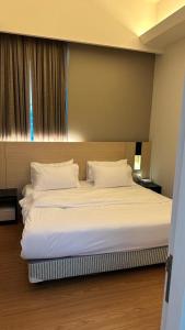 a bedroom with a large bed with white sheets and pillows at Swiss Garden Residence in Kuala Lumpur