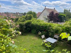 a table and two chairs sitting in a garden at Chez Katia in Semur-en-Auxois
