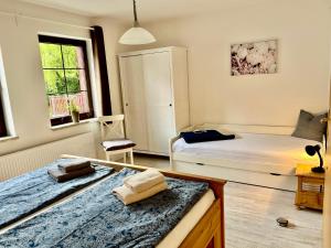 een slaapkamer met 2 bedden en een tafel bij Große Ferienwohnungen 5 - 8 "Pumphut's Scheune" in Lengenfeld