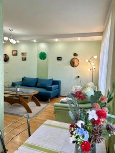 a living room with a blue couch and a table at Apartments in the city centre, near the park in Rivne