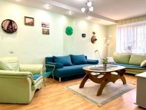 a living room with blue couches and a table at Apartments in the city centre, near the park in Rivne