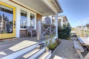 un porche delantero de una casa con puerta amarilla en Sweet Buttercup by Seabrook Hospitality, en Pacific Beach