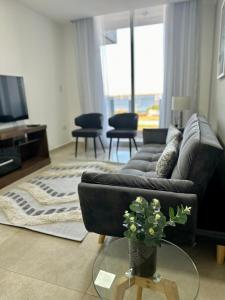 a living room with a couch and a table with a vase of flowers at Rio Suits Apartments C in Posadas