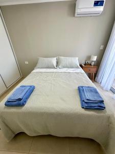 a bedroom with a bed with blue towels on it at Rio Suits Apartments C in Posadas +18 photos