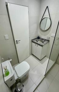 a bathroom with a toilet and a sink and a mirror at Rio Suits Apartments C in Posadas