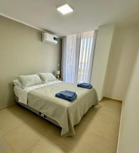 a bedroom with a bed with two towels on it at Rio Suits Apartments C in Posadas