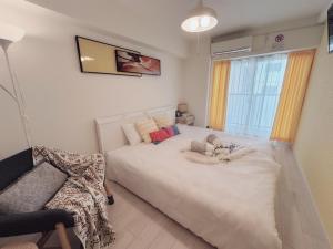 una camera da letto con un grande letto bianco e una sedia di OSAKA SUNSHINE TOWER92 ad Osaka