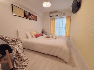 una camera da letto con un grande letto bianco e una finestra di OSAKA SUNSHINE TOWER92 ad Osaka