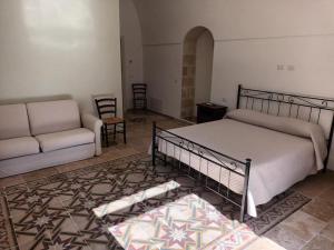 a bedroom with a bed and a couch at Dimora '900 in Poggiorsini