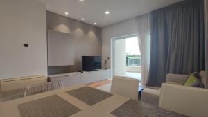 a living room with a dining room table and a television at Skiper Apartments & Golf Resort in Savudrija