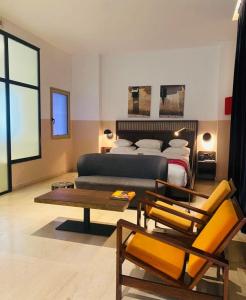 a living room with a bed and a couch at Hotel Lepic in Abidjan