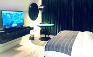 - une chambre avec un lit, une télévision et une table dans l'établissement Hotel Lepic, à Abidjan