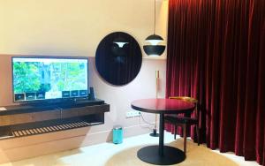 Pokój ze stołem, telewizorem i czerwoną zasłoną w obiekcie Hotel Lepic w mieście Abidżan
