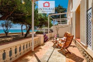 a patio with a chair and a sign that reads imperial palms at Sal de Mar - Casa La Fosca in Palamós