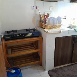 Il comprend une cuisine équipée d'une cuisinière et d'un comptoir avec de la vaisselle. dans l'établissement Phyl, à Kitengela 