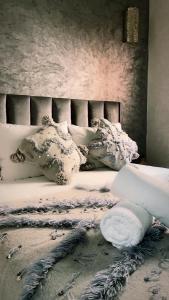 een slaapkamer met een bed met witte lakens en kussens bij Riad Darnooz in Marrakesh