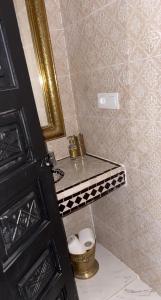een badkamer met een wastafel, een spiegel en een toilet bij Riad Darnooz in Marrakesh
