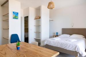 a bedroom with a bed and a wooden table at Residence Roc E Mare Cargèse in Cargèse