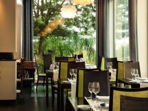 een restaurant met tafels en stoelen en een groot raam bij Jupiter Algarve Hotel in Portimão