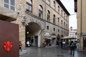 a street with an archway in a building with people walking around at Arch Apartment Duomo - Florence in Florence