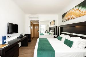 Cama ou camas em um quarto em Jupiter Algarve Hotel