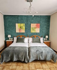 - une chambre avec 2 lits et un mur vert dans l'établissement Casa Rural Aitonaren Etxea, à Urturi