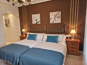 - une chambre avec un grand lit et 2 oreillers bleus dans l'établissement Casa Rural Aitonaren Etxea, à Urturi