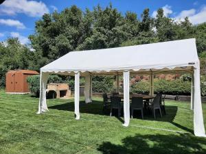 une tente blanche avec des tables et des chaises sur une pelouse dans l'établissement Casa Rural Aitonaren Etxea, à Urturi