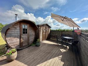 a wooden deck with a table and an umbrella at Haapsu Holiday Home in Haapsu