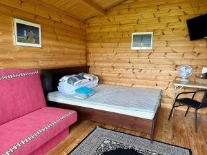 a room with a couch and a bed in a log cabin at Haapsu Holiday Home in Haapsu