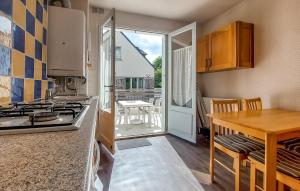Una cocina con estufa y mesa y un comedor. en Gorgeous Apartment In Saint-Lunaire, en Saint-Lunaire