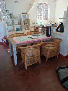 une cuisine avec une table, 4 chaises et un comptoir dans l'établissement Kuwona Cottage, à Senga