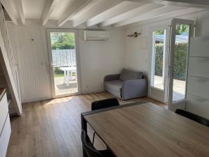 una sala de estar con una mesa y un sofá en Chalet familial La Hume, en Gujan-Mestras
