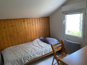Un dormitorio pequeño con una cama y una ventana. en Chalet familial La Hume, en Gujan-Mestras