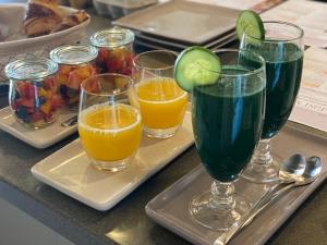a tray with four glasses of juice and fruit at Lut's Place in Lincoln